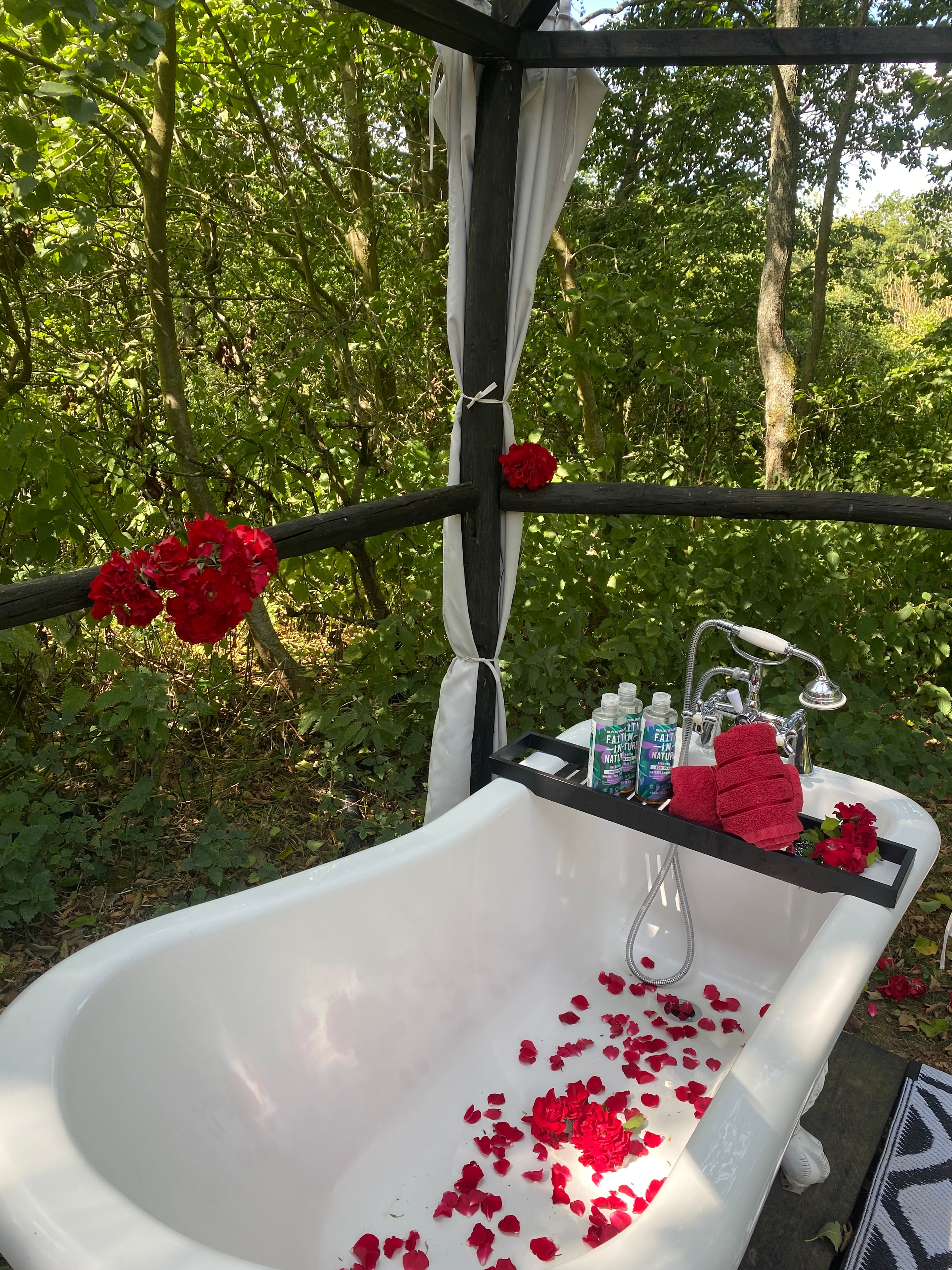 Outdoor bath with rose petals and red flowers