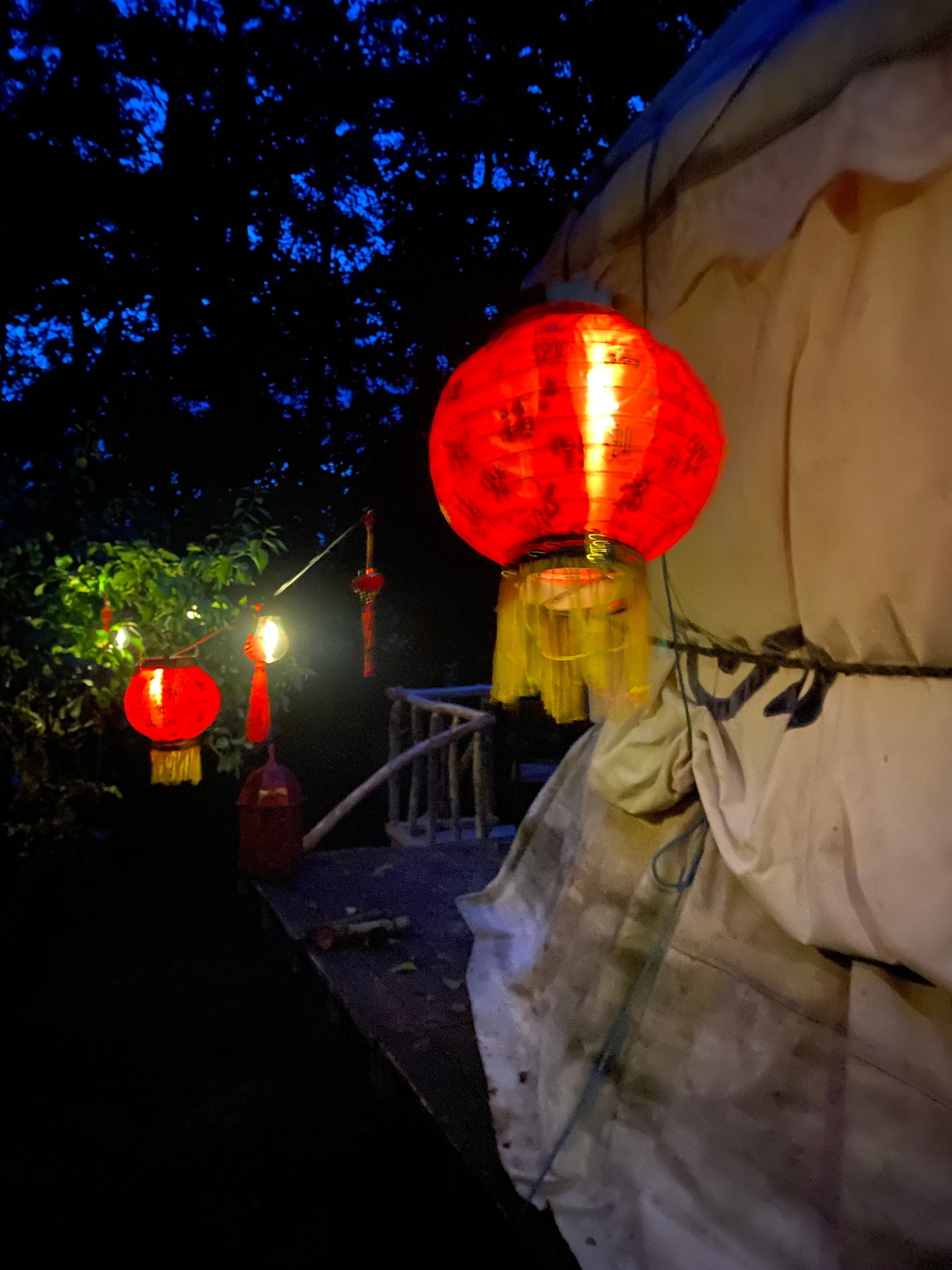 Red lanterns glowing against the yurt at night